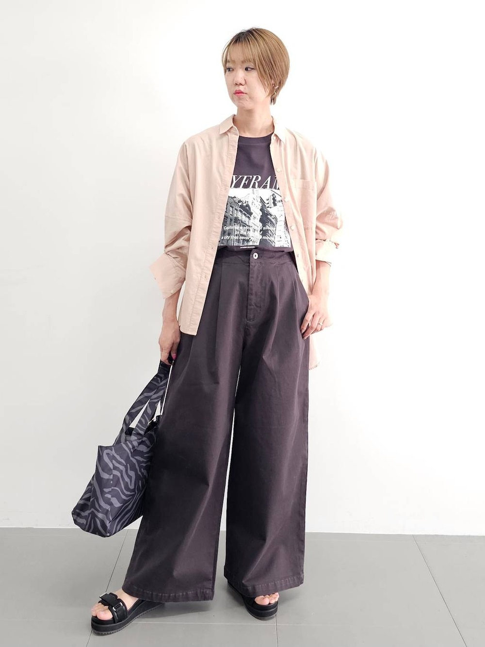 ブラック系のサンダル、グレー系のチノパンツ、ピンク系のシャツ/ブラウスを着用したレディースの夏コーディネートの1枚目の写真