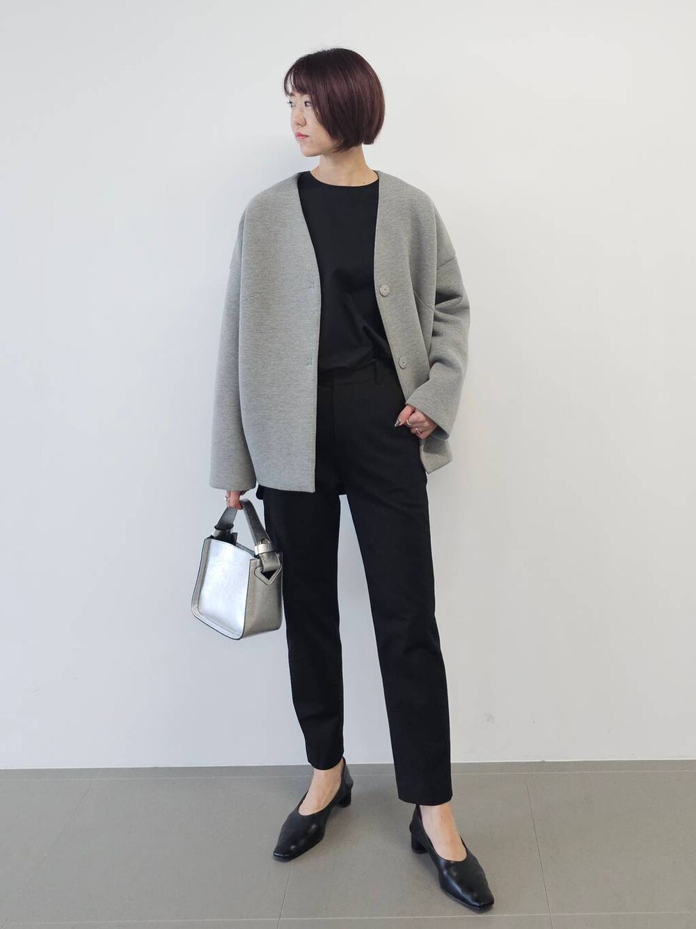 シルバー系のショルダーバッグ、ブラック系のシャツ/ブラウス、ブラック系のパンプスを着用したレディースの冬コーディネートの1枚目の写真