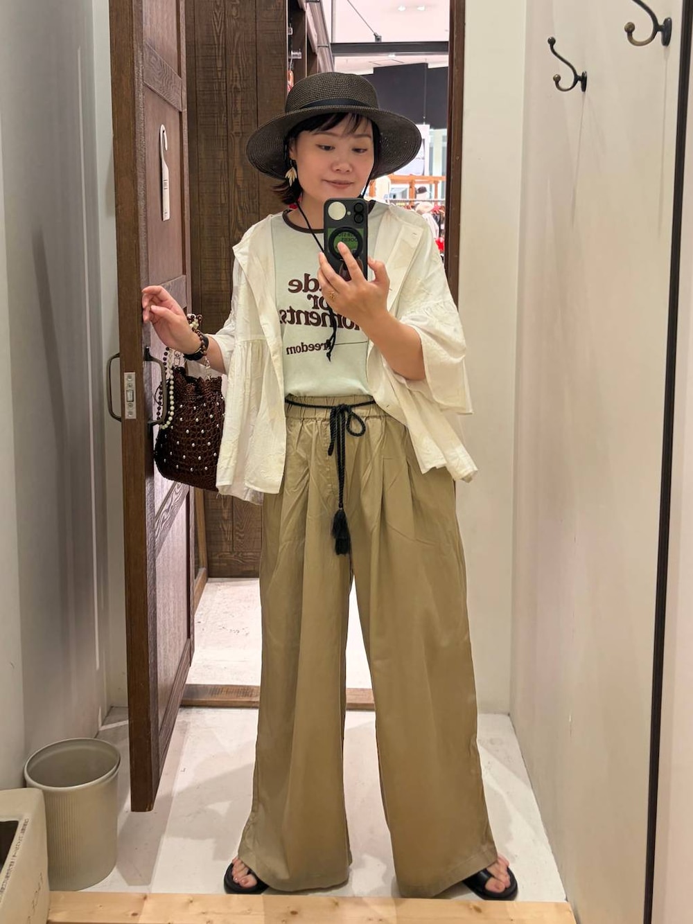 ベージュ系のその他パンツ、ホワイト系のシャツ/ブラウス、ブラウン系のショルダーバッグを着用したレディースの春コーディネートの1枚目の写真
