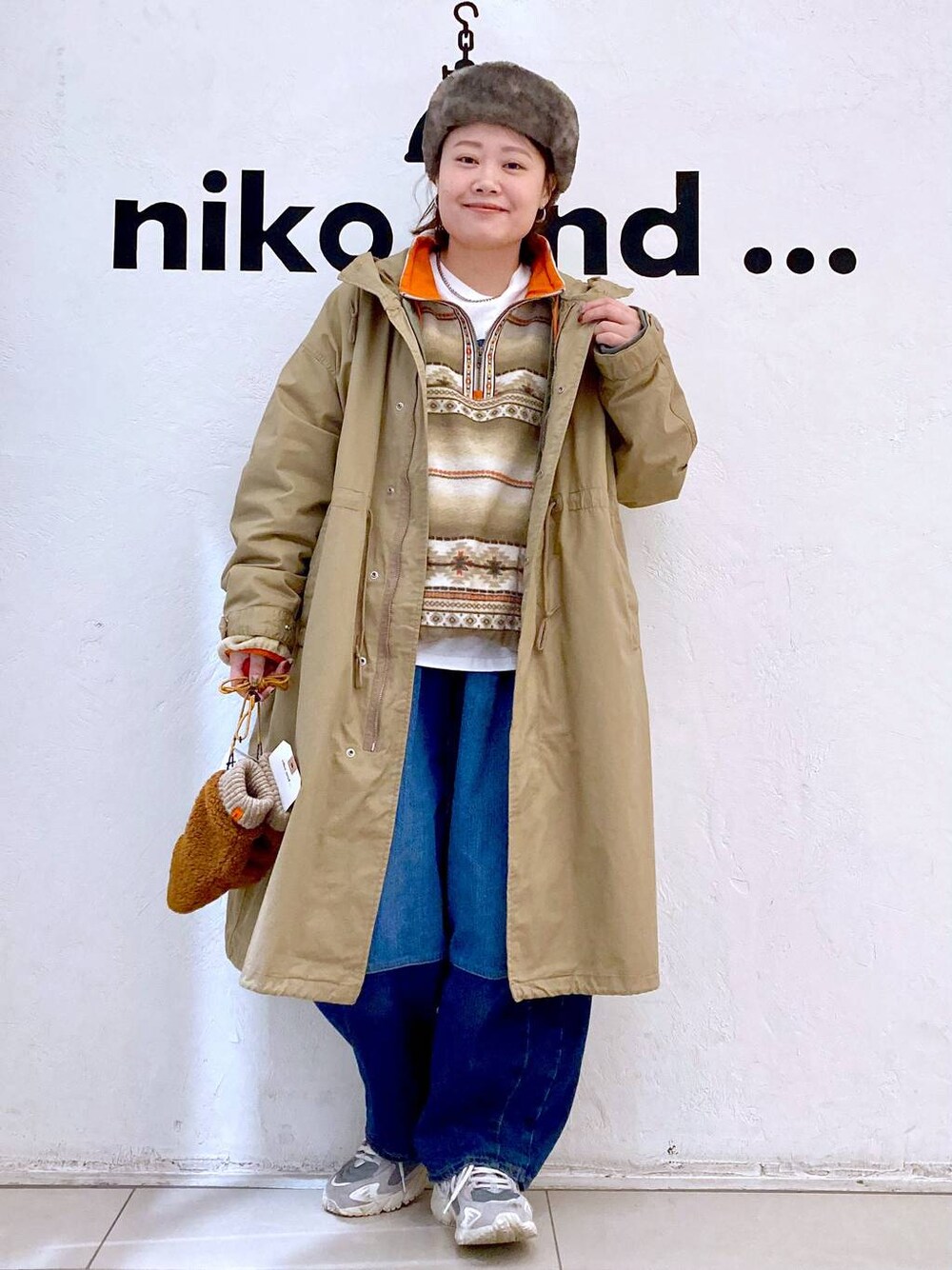イエロー系のモッズコート、ブルー系のデニムパンツ、ホワイト系のTシャツ/カットソーを着用したレディースの秋コーディネートの1枚目の写真