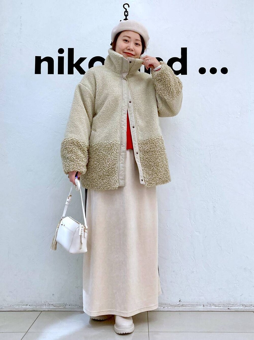 ベージュ系のその他アウター、ブラウン系のショルダーバッグ、ベージュ系のブーツを着用したレディースの冬コーディネートの1枚目の写真