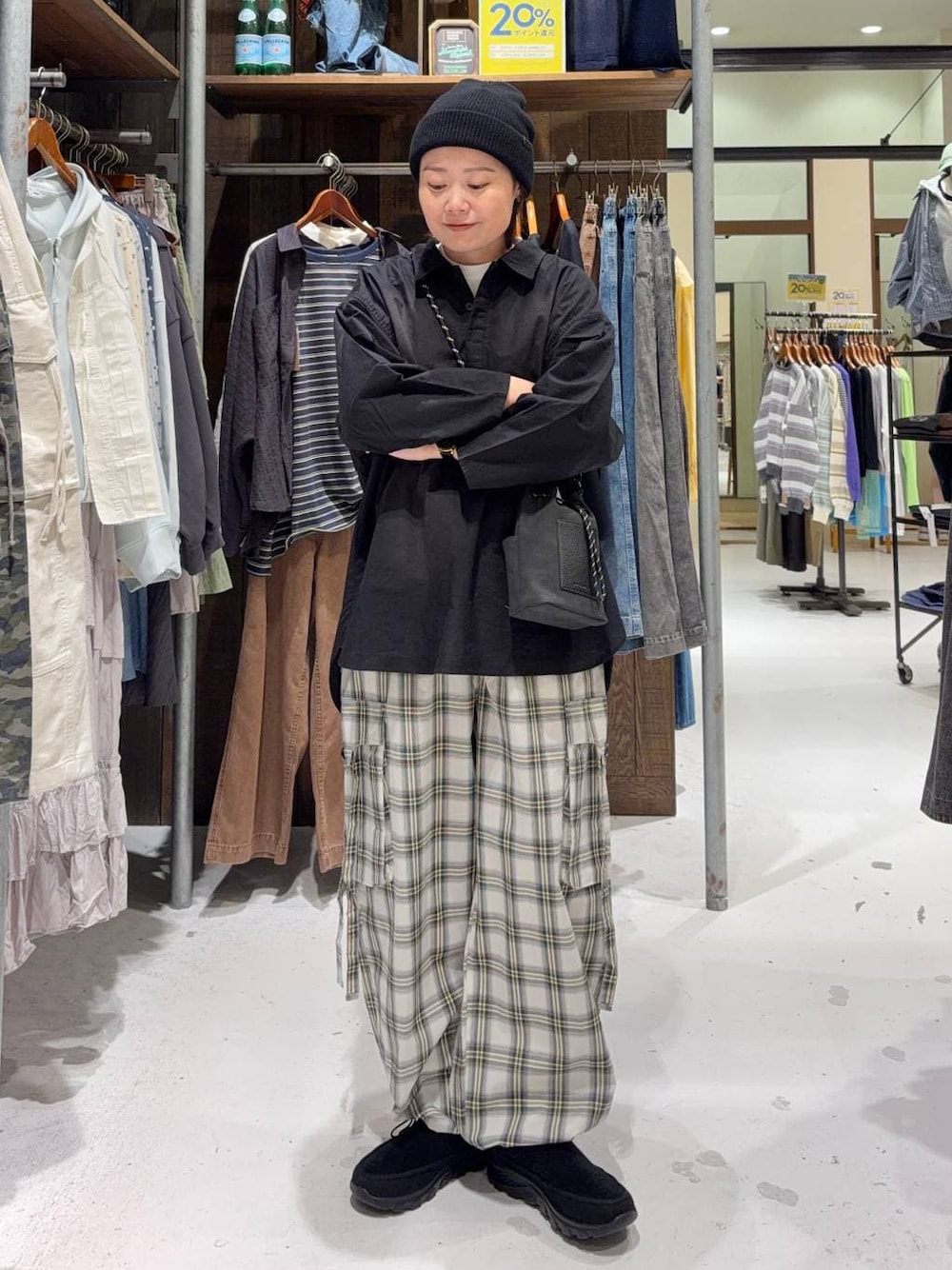 ブラック系のショルダーバッグ、ブラック系のその他シューズ、ホワイト系のTシャツ/カットソーを着用したレディースの春コーディネートの1枚目の写真