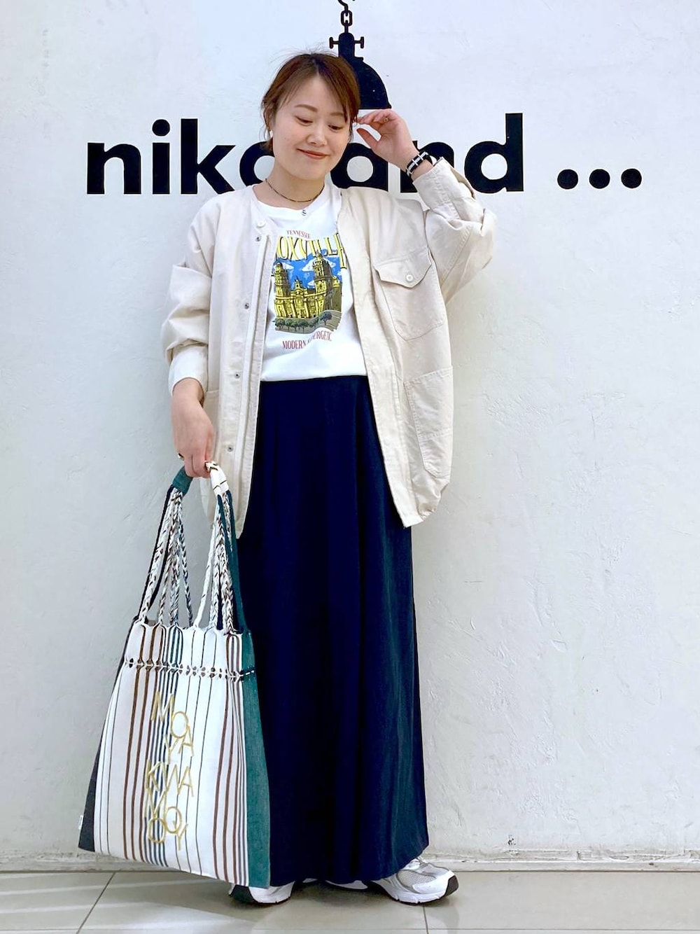 ホワイト系のTシャツ/カットソー、ブラック系のトートバッグ、ベージュ系のブルゾンを着用したレディースの春コーディネートの1枚目の写真