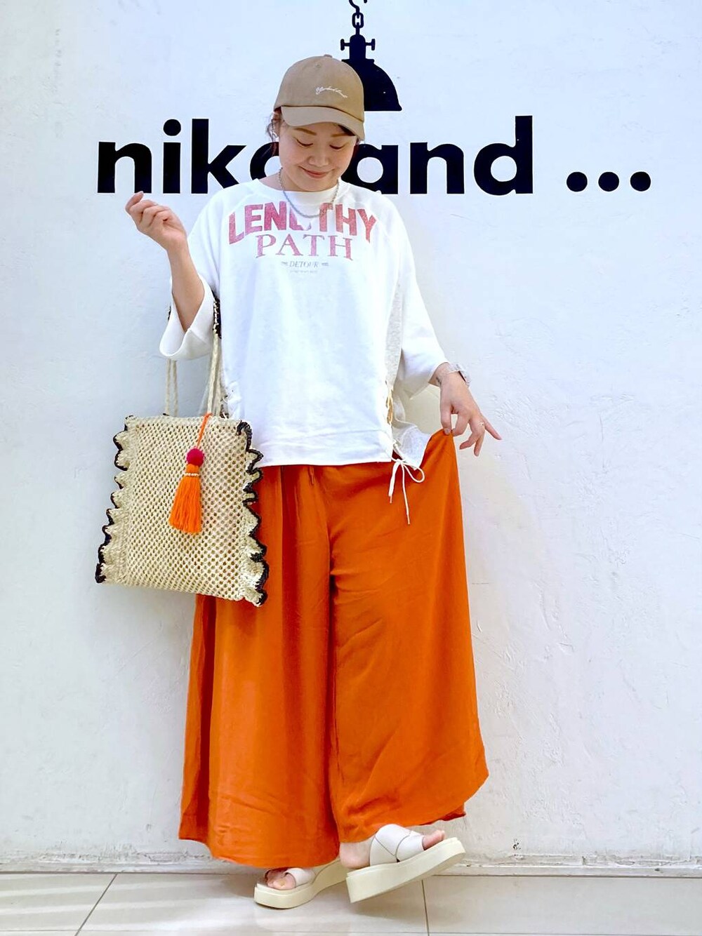 ベージュ系のサンダル、ベージュ系のトートバッグ、ホワイト系のデジタル腕時計を着用したレディースの夏コーディネートの1枚目の写真