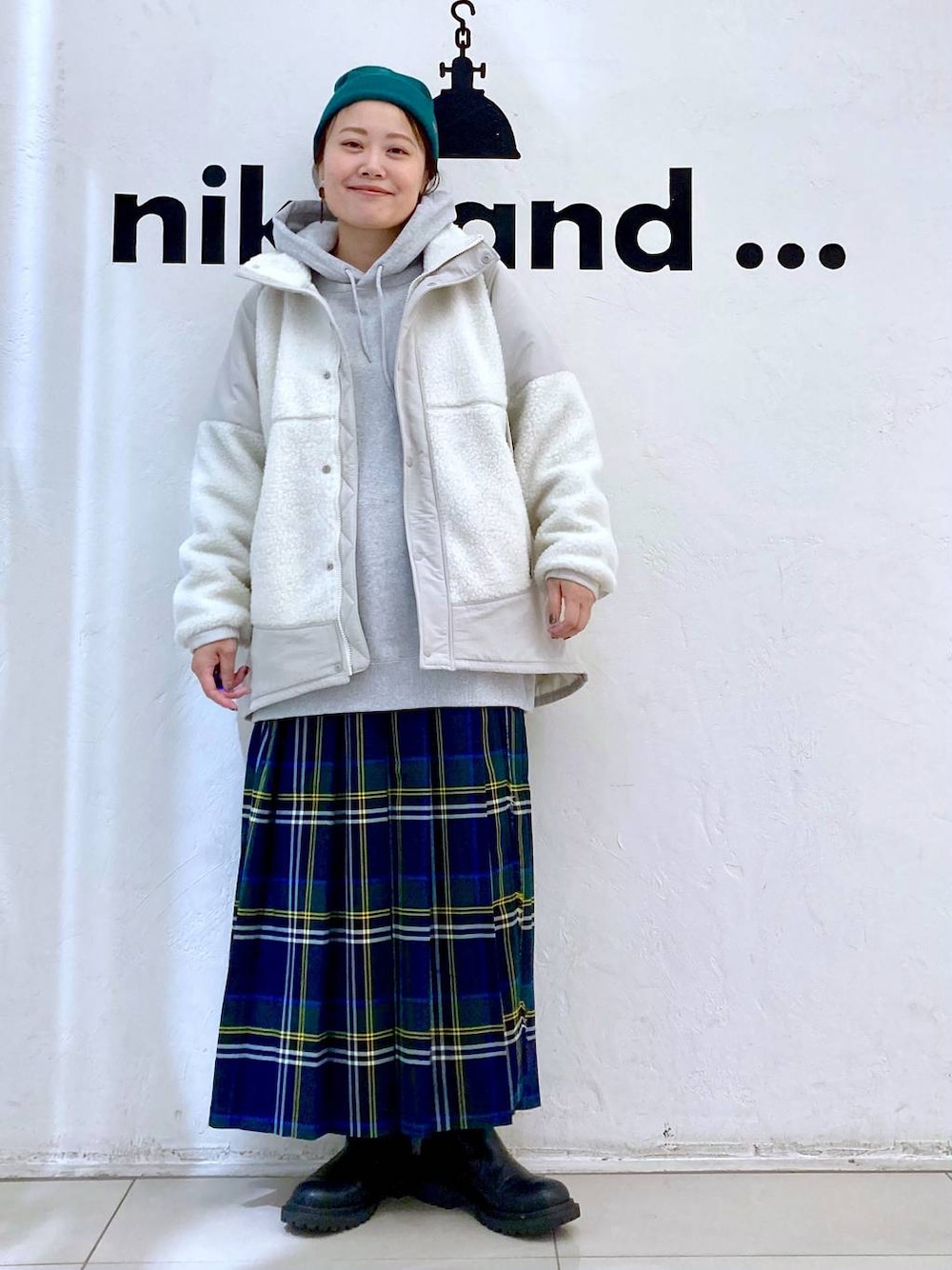 グレー系のパーカー、ベージュ系のブルゾン、ブラウン系のスカートを着用したレディースの秋コーディネートの1枚目の写真