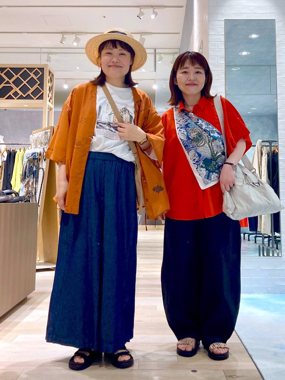ブルー系のその他パンツ、レッド系のシャツ/ブラウス、ブラック系のサンダルを着用したレディースの春コーディネートの1枚目の写真