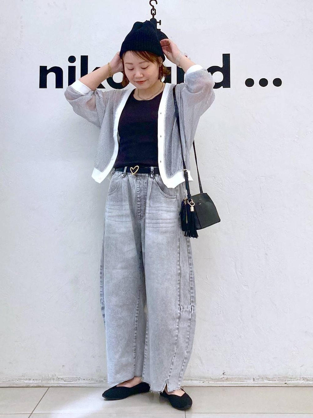 ホワイト系のカーディガン/ボレロ、グレー系のデニムパンツ、ブラック系のショルダーバッグを着用したレディースの春コーディネートの1枚目の写真