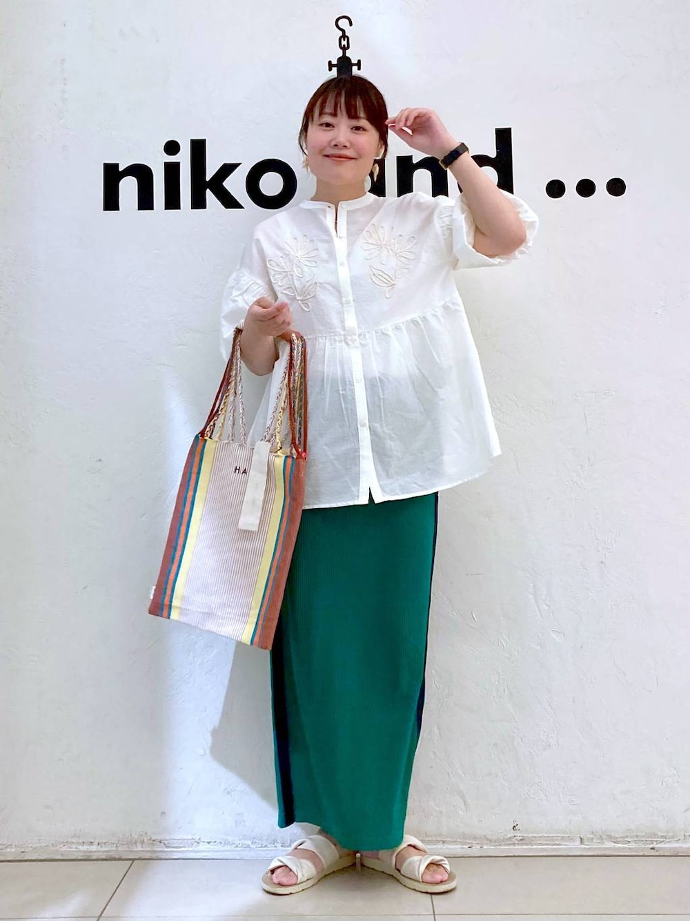 グリーン系のスカート、その他のトートバッグ、ホワイト系のシャツ/ブラウスを着用したレディースの夏コーディネートの1枚目の写真