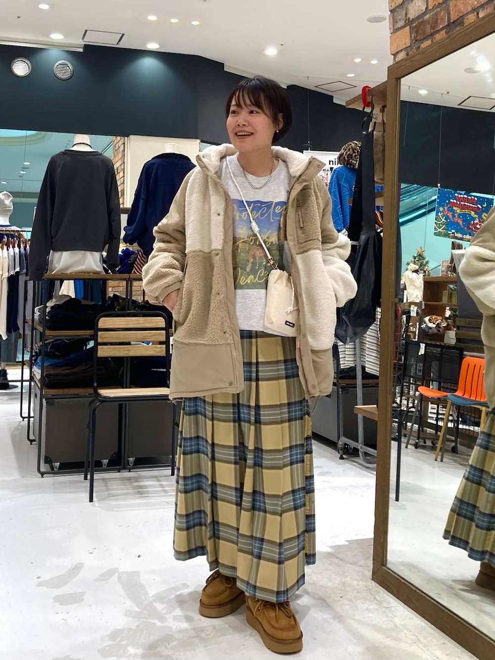 ホワイト系のショルダーバッグ、イエロー系のモカシン/デッキシューズ、ベージュ系のその他アウターを着用したレディースの秋コーディネートの1枚目の写真