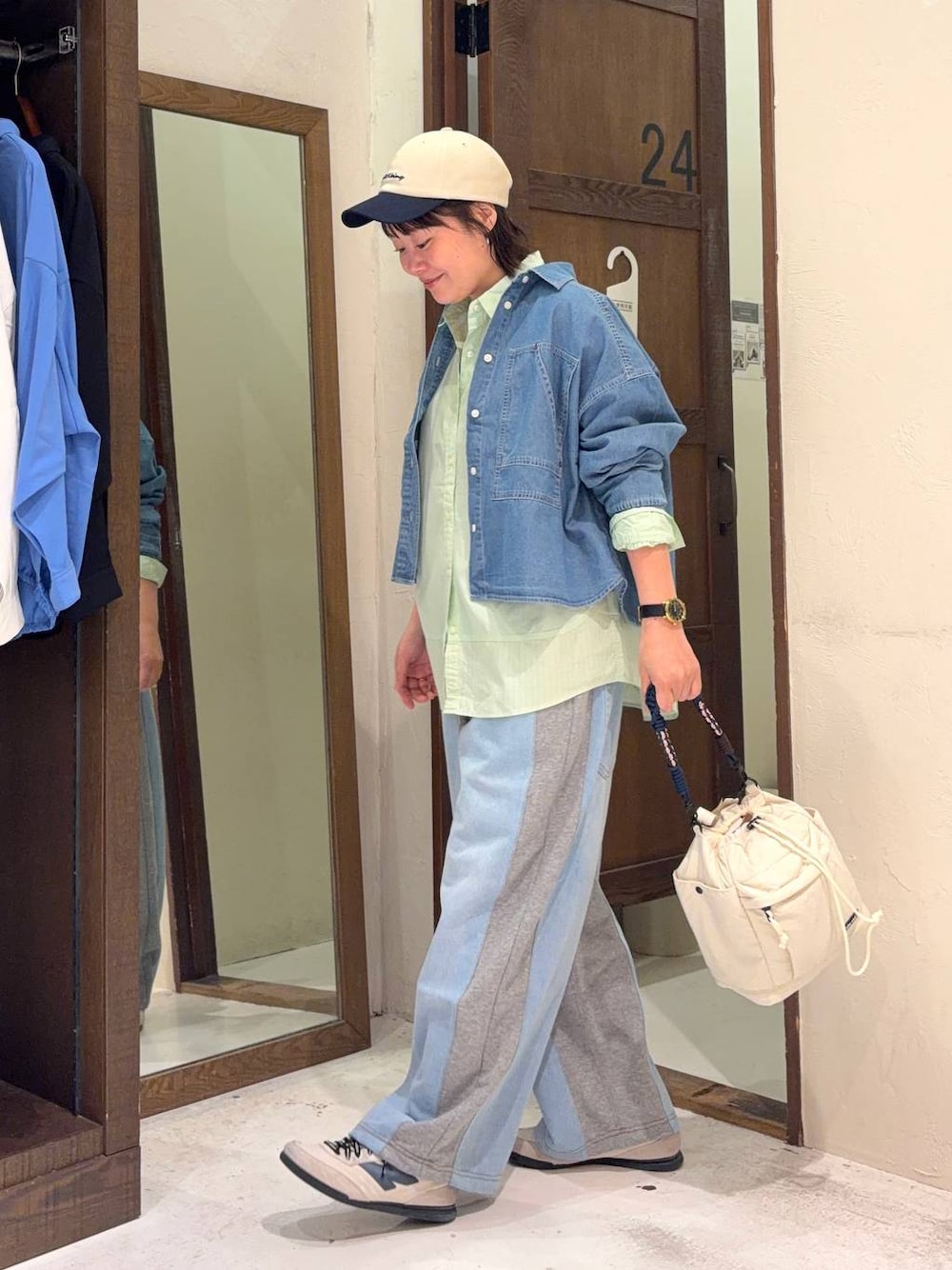 グレー系のデニムパンツ、グリーン系のシャツ/ブラウス、ベージュ系のショルダーバッグを着用したレディースの春コーディネートの1枚目の写真