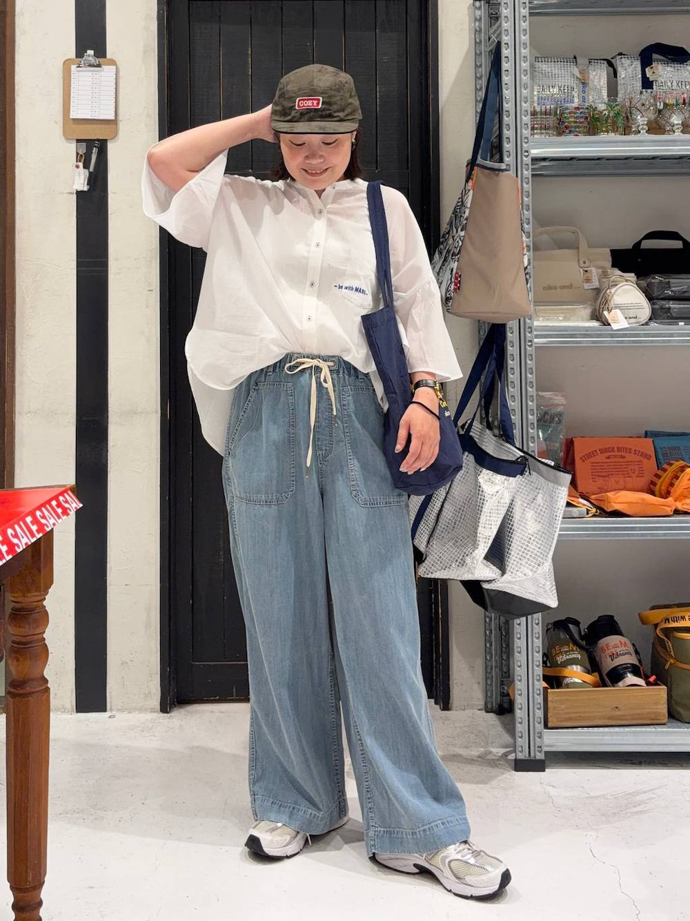 ブルー系のトートバッグ、ブルー系のデニムパンツ、その他のキャップを着用したレディースの夏コーディネートの1枚目の写真