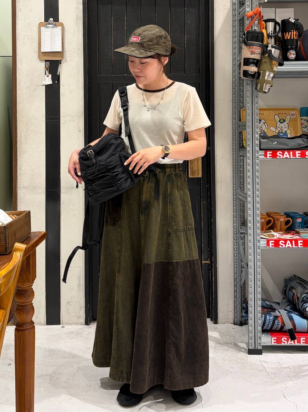 ブラック系のバレエシューズ、ブラック系のバックパック/リュック、ベージュ系のTシャツ/カットソーを着用したレディースの夏コーディネートの1枚目の写真