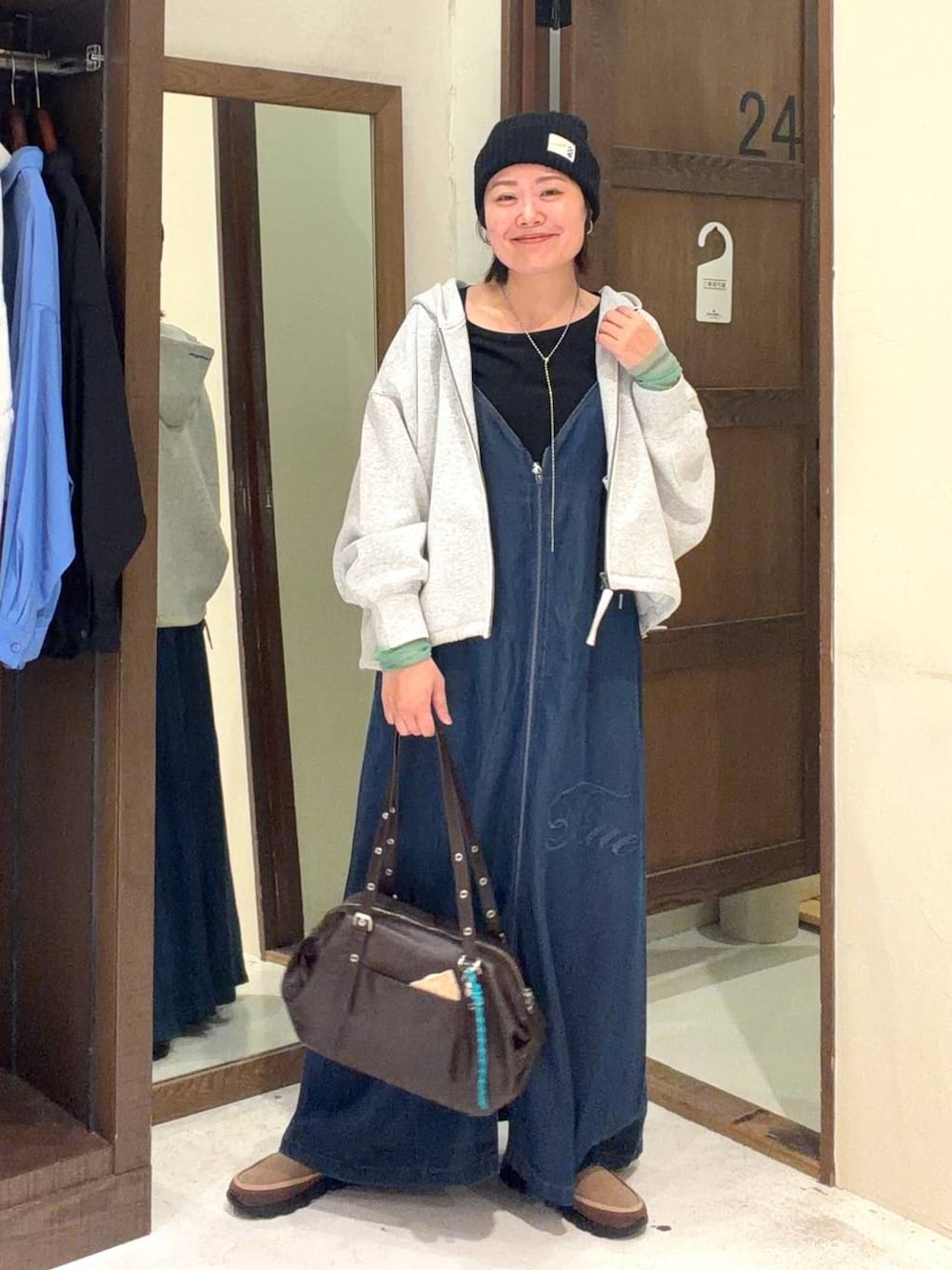 ブラウン系のボストンバッグ、ブラック系のTシャツ/カットソー、グレー系のパーカーを着用したレディースの春コーディネートの1枚目の写真