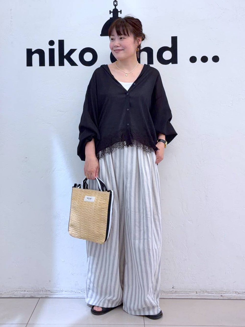 ブラック系のシャツ/ブラウス、ベージュ系のトートバッグを着用したレディースの夏コーディネートの1枚目の写真