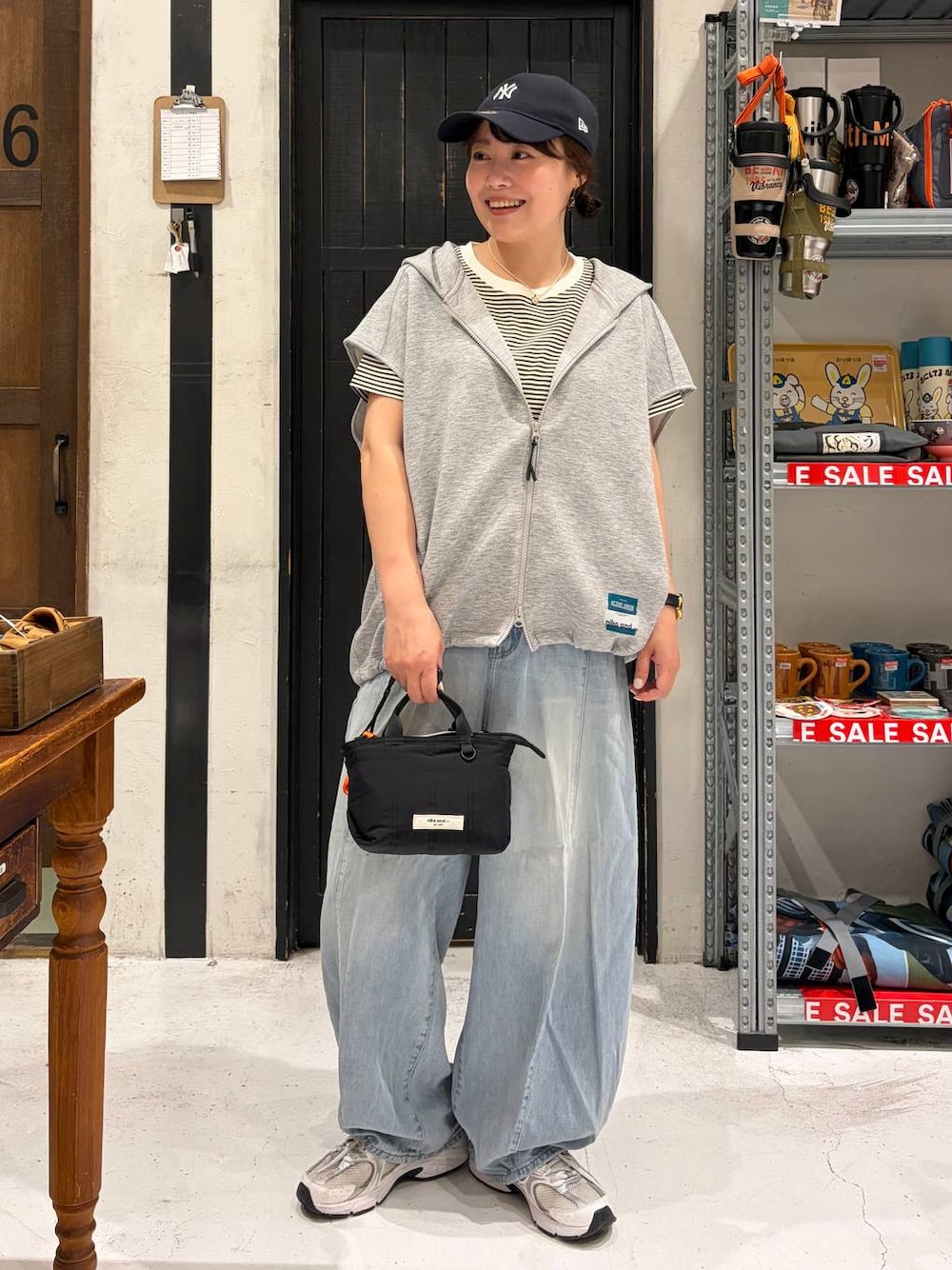 ブラック系のトートバッグ、その他のベスト、ベージュ系のTシャツ/カットソーを着用したレディースの夏コーディネートの1枚目の写真