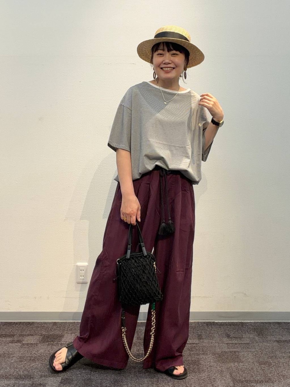 レッド系のその他パンツ、ブラック系のトートバッグ、ホワイト系のTシャツ/カットソーを着用したレディースの夏コーディネートの1枚目の写真