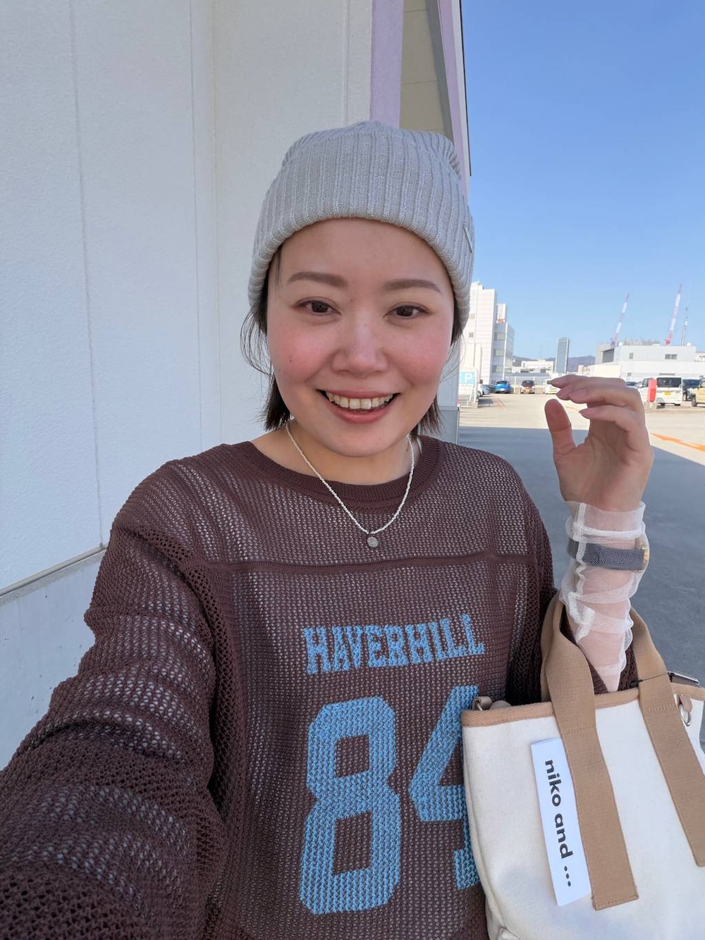 グレー系のデニムパンツ、ホワイト系のTシャツ/カットソー、その他のショルダーバッグを着用したレディースの春コーディネートの1枚目の写真