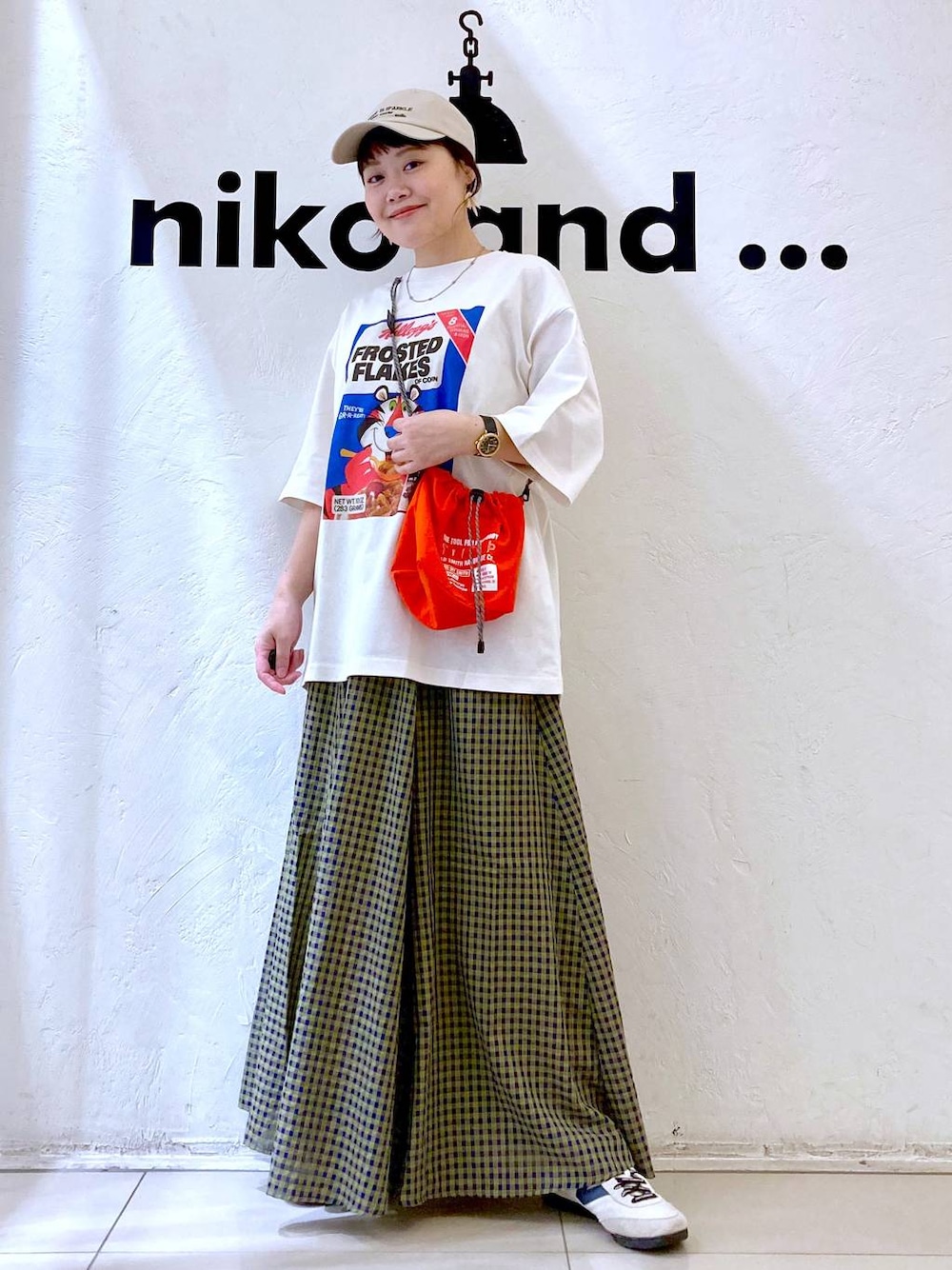 ホワイト系のスニーカー、オレンジ系のショルダーバッグ、ホワイト系のTシャツ/カットソーを着用したレディースの春コーディネートの1枚目の写真