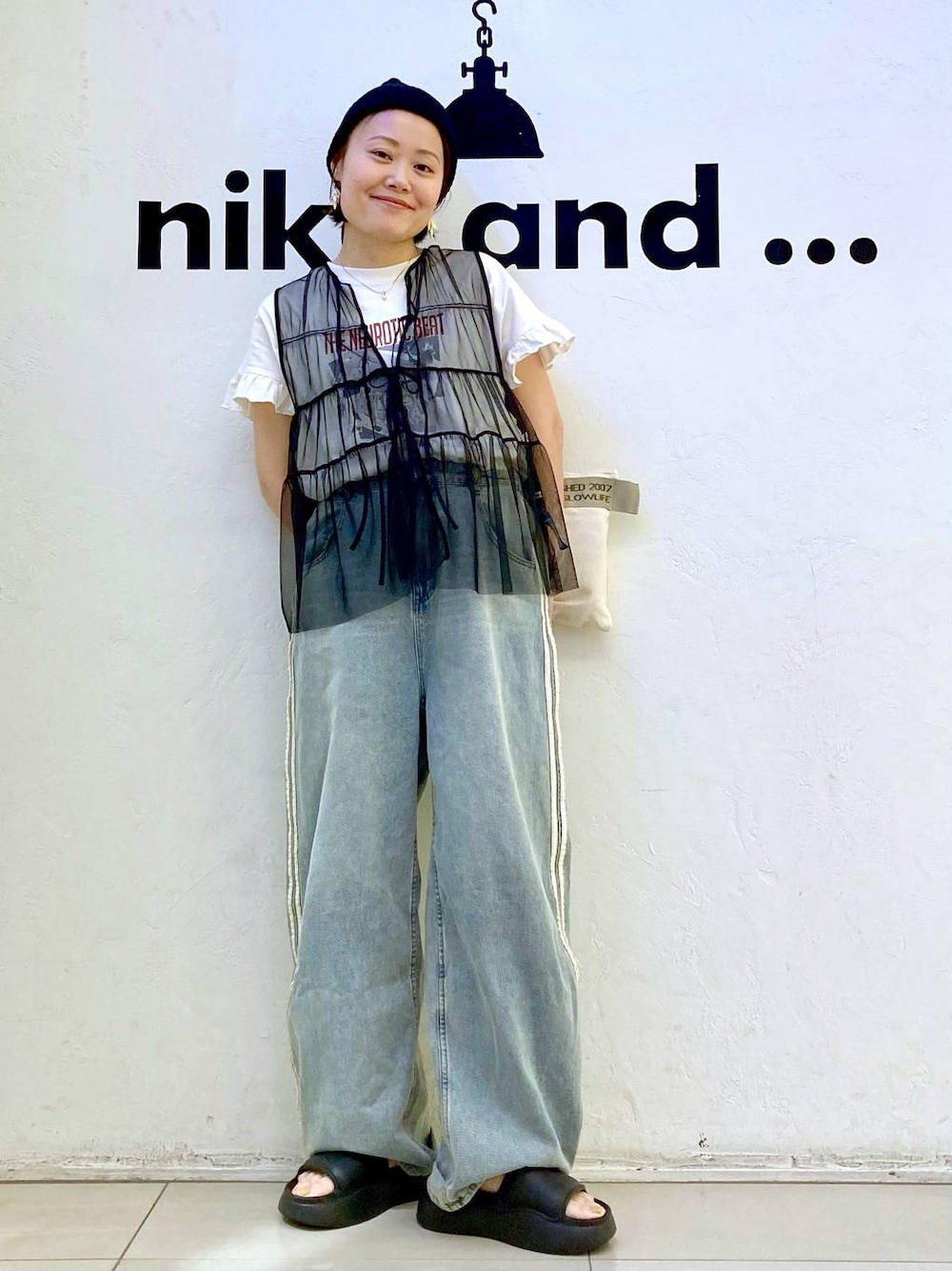 ブラック系のサンダル、ホワイト系のTシャツ/カットソー、ブラック系のベストを着用したレディースの夏コーディネートの1枚目の写真