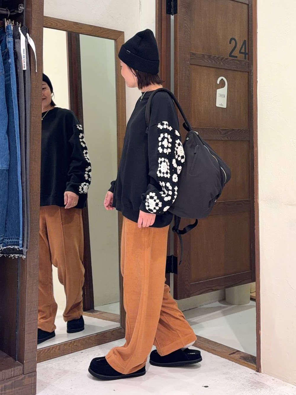 ブラック系のスウェット、オレンジ系のその他パンツ、ブラック系のモカシン/デッキシューズを着用したレディースの春コーディネートの1枚目の写真