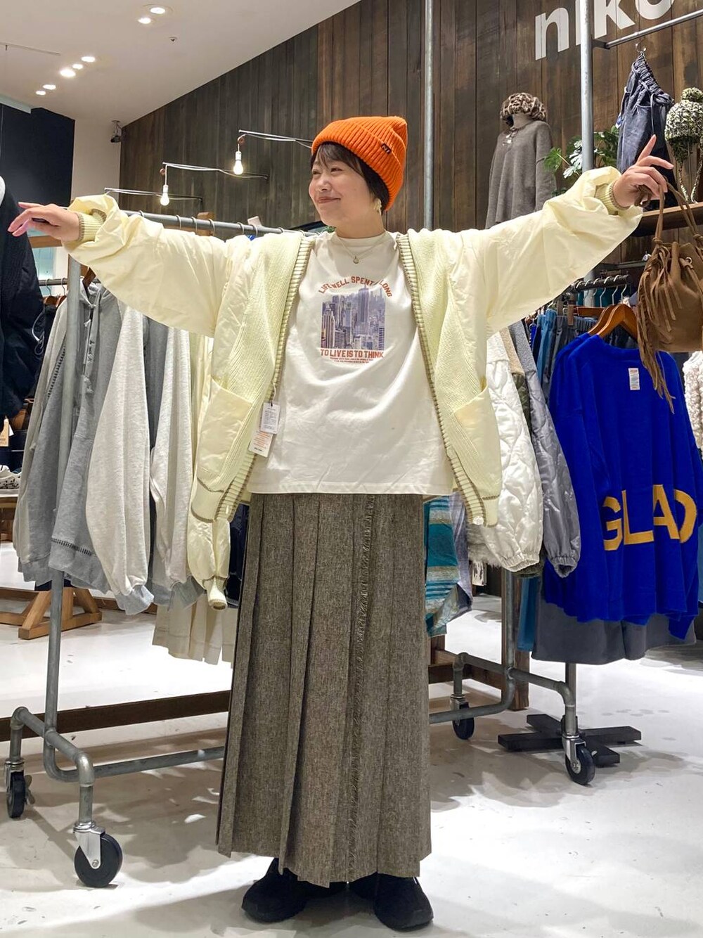 ブラウン系のスカート、ブラウン系のショルダーバッグ、ホワイト系のTシャツ/カットソーを着用したレディースの秋コーディネートの1枚目の写真