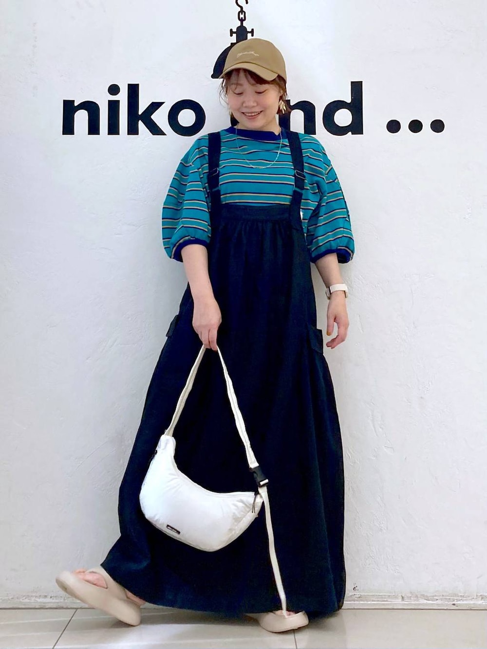 ベージュ系のサンダル、ホワイト系のショルダーバッグ、グリーン系のTシャツ/カットソーを着用したレディースの春コーディネートの1枚目の写真