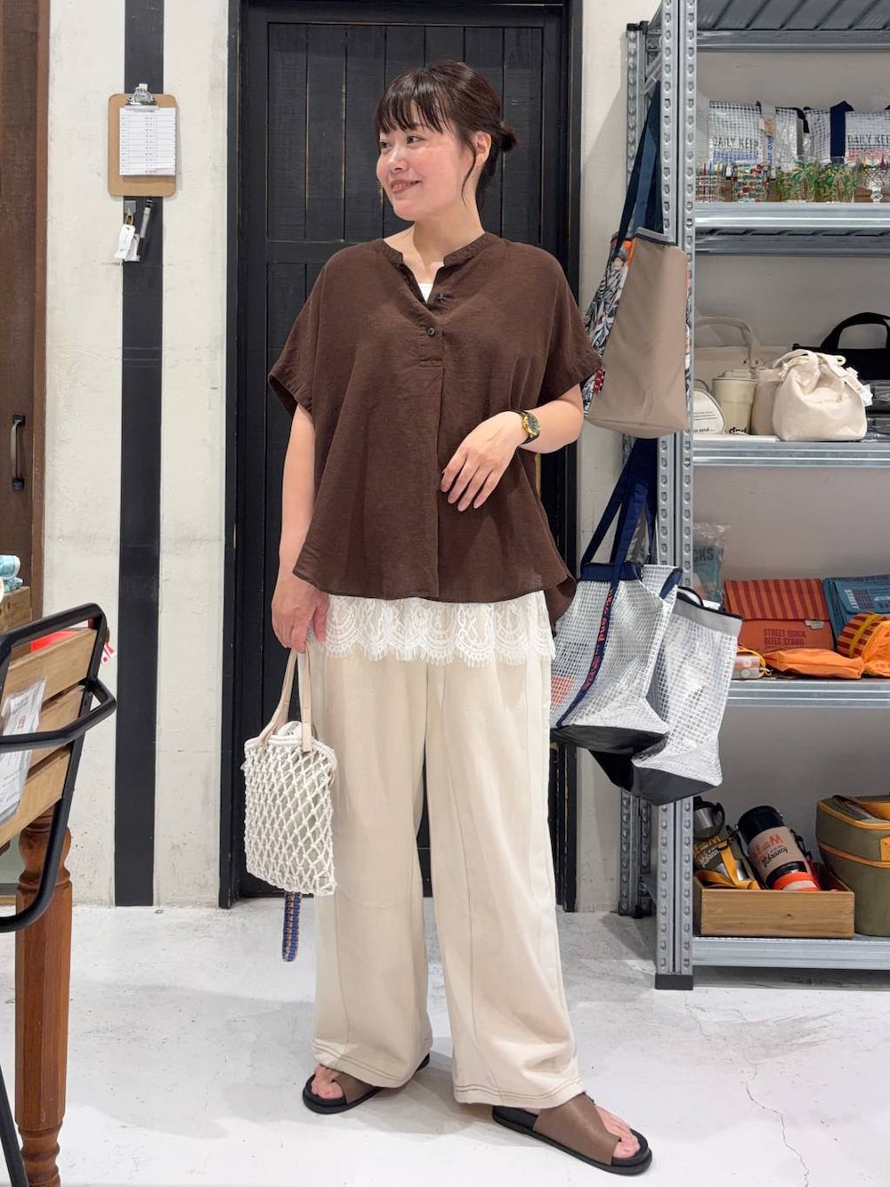 ベージュ系のデニムパンツ、ベージュ系のトートバッグ、ブラウン系のシャツ/ブラウスを着用したレディースの夏コーディネートの1枚目の写真