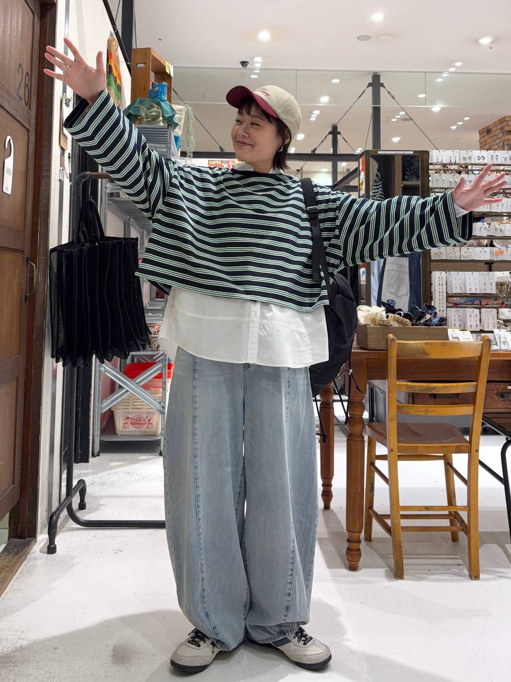 ブラック系のバックパック/リュック、ホワイト系のシャツ/ブラウス、ブルー系のデニムパンツを着用したレディースの冬コーディネートの1枚目の写真