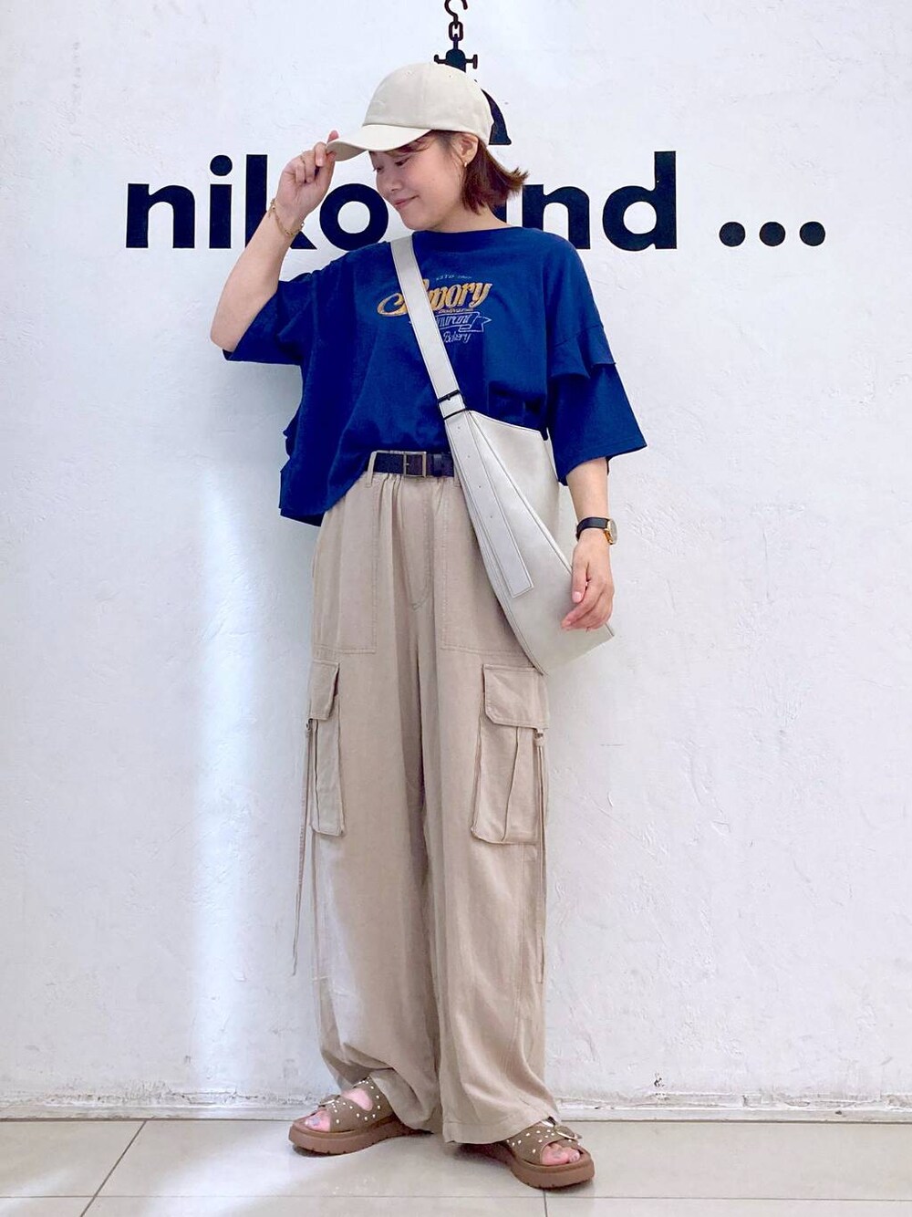 ベージュ系のサンダル、ブルー系のTシャツ/カットソー、グレー系のショルダーバッグを着用したレディースの夏コーディネートの1枚目の写真