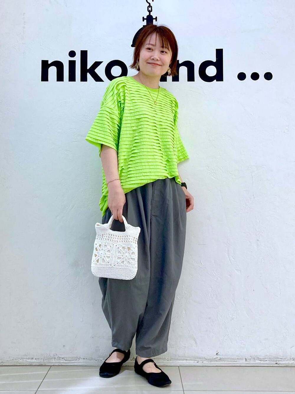 ホワイト系のショルダーバッグ、グリーン系のTシャツ/カットソー、グレー系のその他パンツを着用したレディースの春コーディネートの1枚目の写真