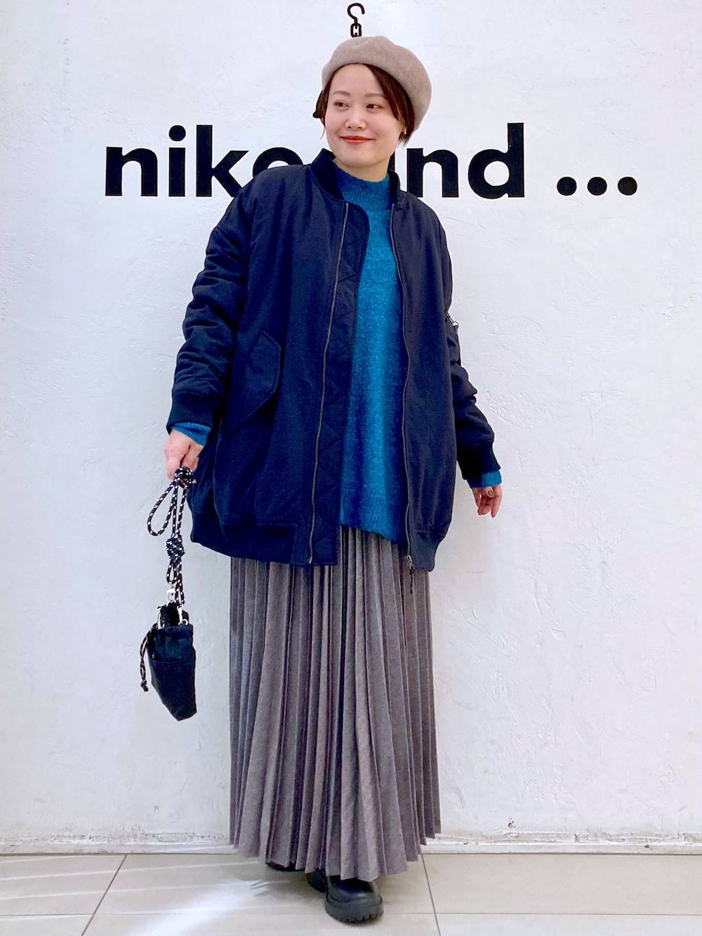 ブラック系のMA-1、グリーン系のニット/セーター、ブラック系のブーツを着用したレディースの冬コーディネートの1枚目の写真