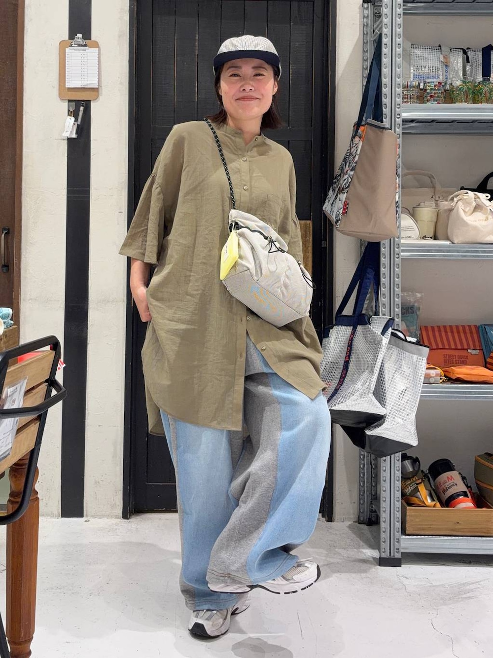 グレー系のデニムパンツ、ベージュ系のショルダーバッグを着用したレディースの夏コーディネートの1枚目の写真
