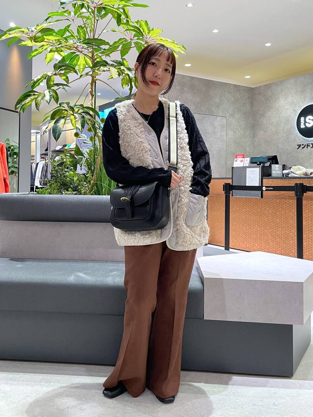 ブラック系のTシャツ/カットソー、ベージュ系のベスト、ブラック系のショルダーバッグを着用したレディースの秋コーディネートの1枚目の写真