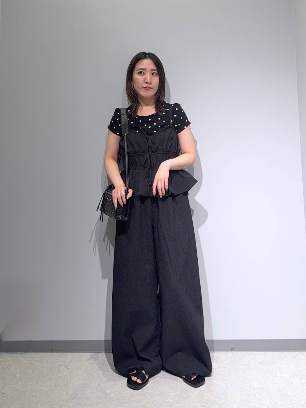 ブラック系のサロペット/オーバーオール、ブラック系のサンダル、ブラック系のショルダーバッグを着用したレディースの夏コーディネートの1枚目の写真
