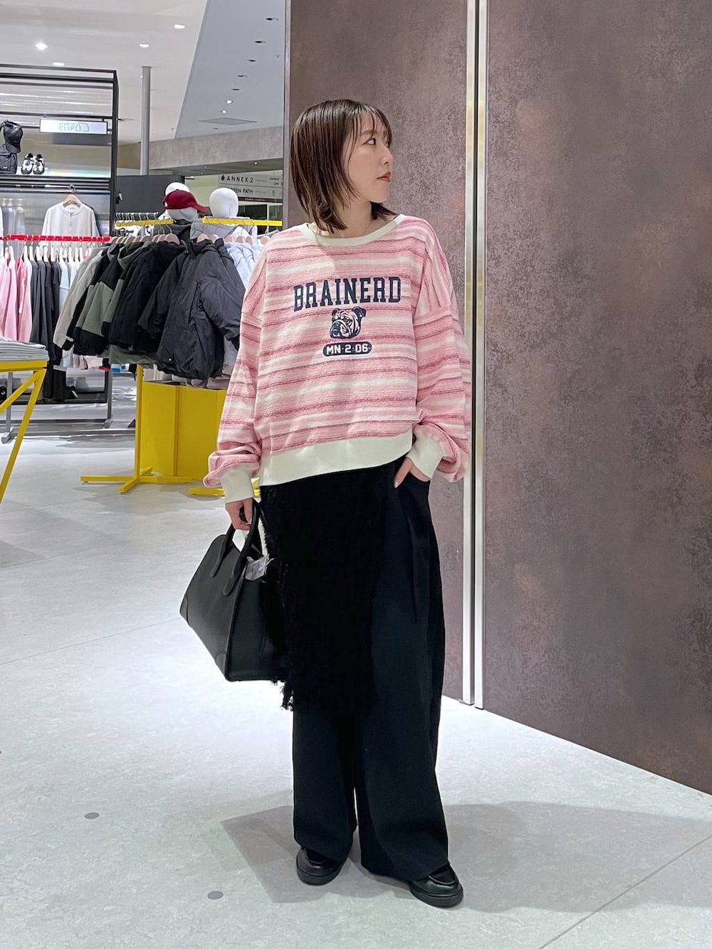 ブラック系のショルダーバッグ、ピンク系のTシャツ/カットソー、シルバー系のスマホグッズを着用したレディースの冬コーディネートの1枚目の写真