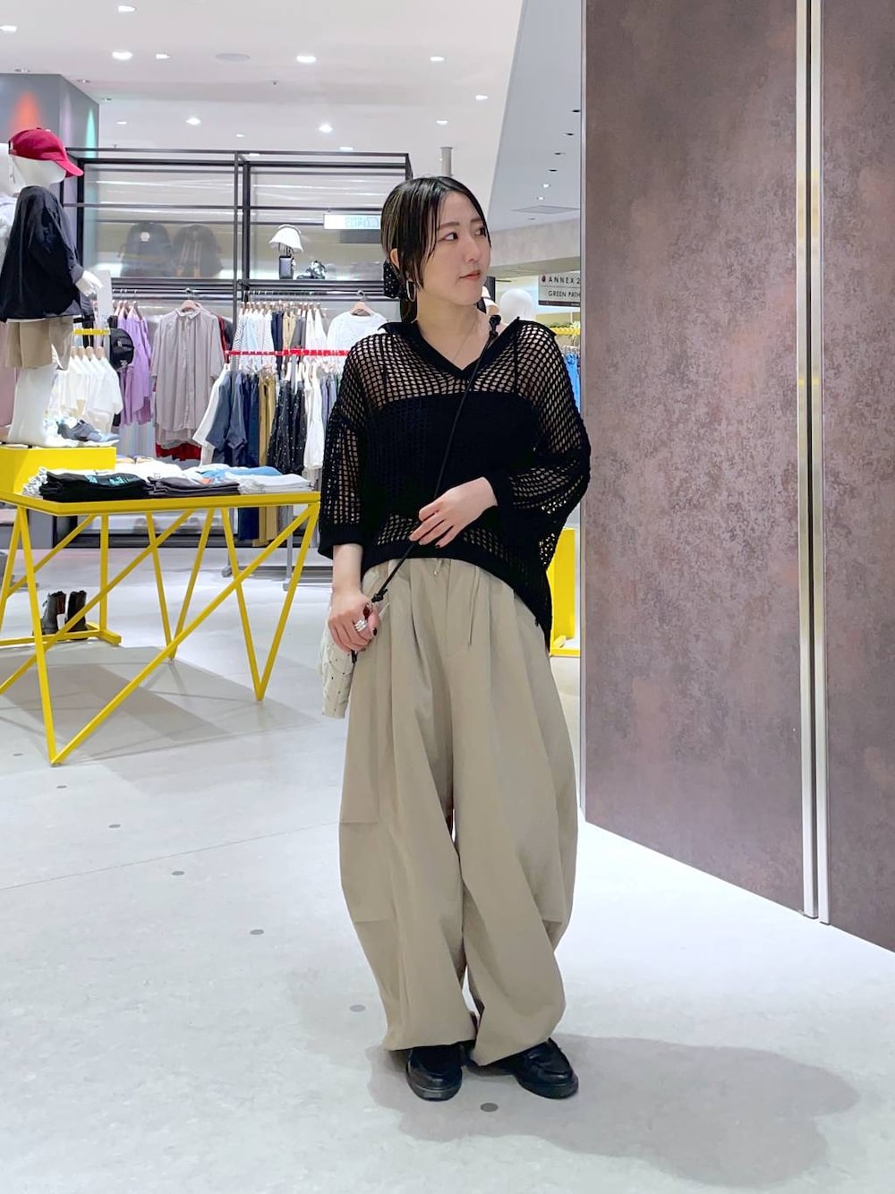 ホワイト系のショルダーバッグ、ブラック系のニット/セーター、ベージュ系のその他パンツを着用したレディースの夏コーディネートの1枚目の写真