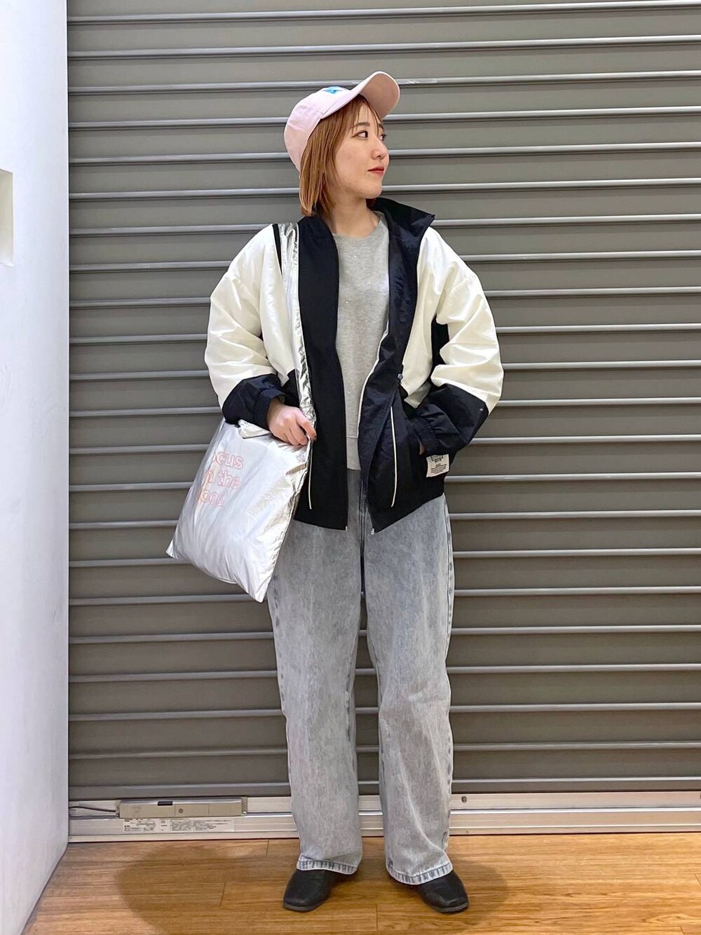 グレー系のTシャツ/カットソー、ブルー系のデニムパンツ、シルバー系のトートバッグを着用したレディースの冬コーディネートの1枚目の写真