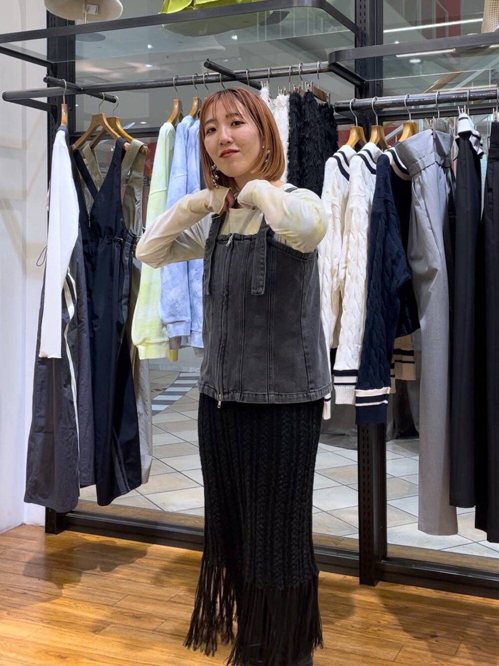 グリーン系のTシャツ/カットソー、ブラック系のベスト、グレー系のデニムパンツを着用したレディースの春コーディネートの1枚目の写真