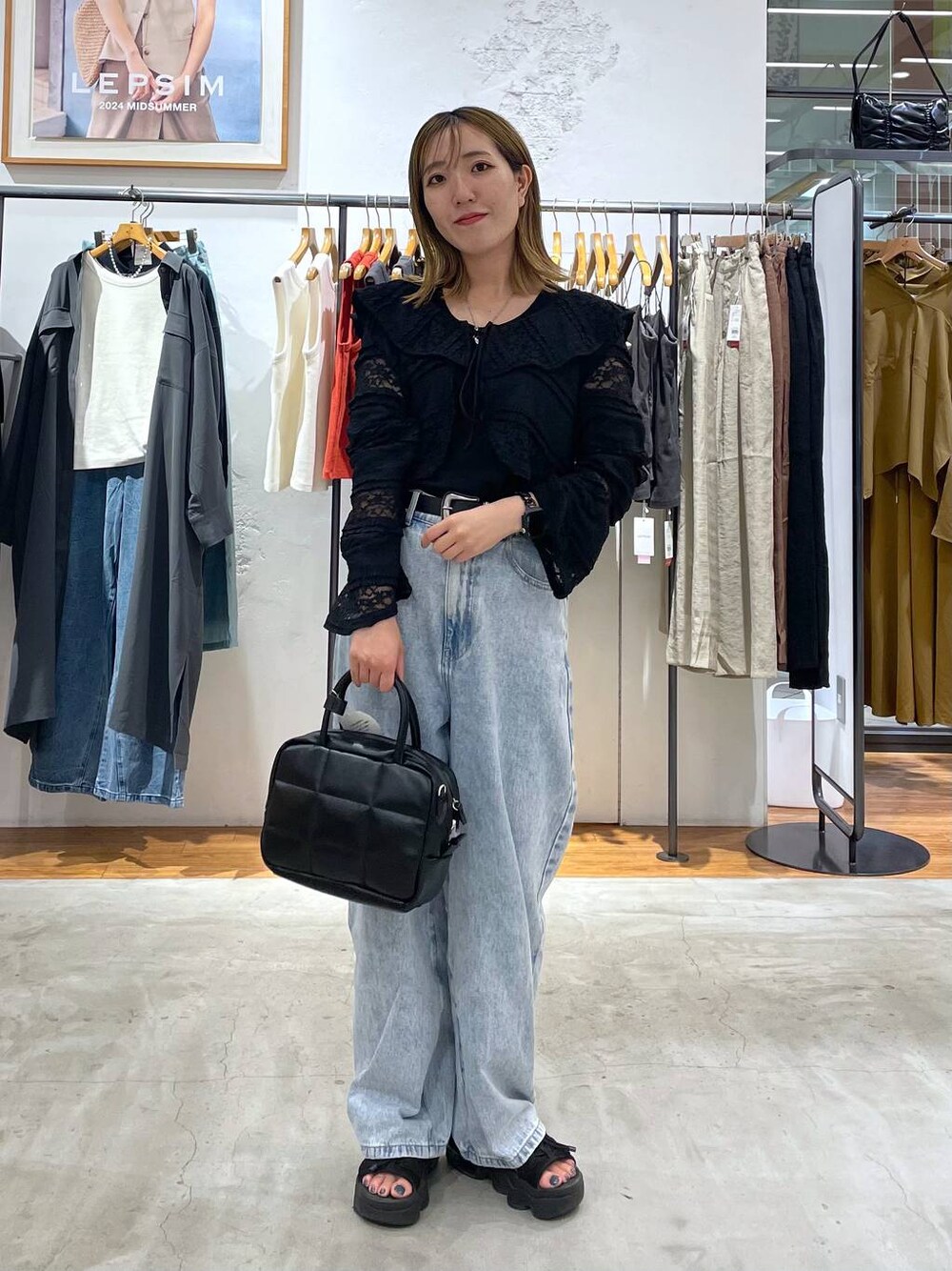 ブルー系のデニムパンツ、ブラック系のカーディガン/ボレロ、ブラック系のベルトを着用したレディースの夏コーディネートの1枚目の写真