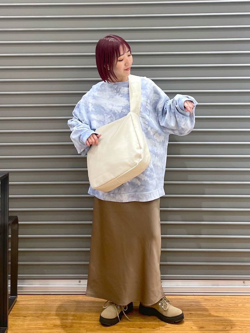 ホワイト系のショルダーバッグ、ベージュ系のブーツ、ブラウン系のスカートを着用したレディースの冬コーディネートの1枚目の写真