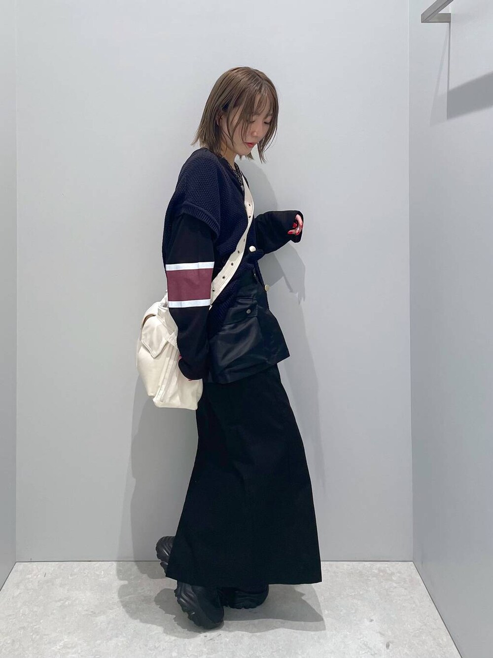 ホワイト系のショルダーバッグ、ブラック系のTシャツ/カットソー、ブラック系のスカートを着用したレディースの秋コーディネートの1枚目の写真