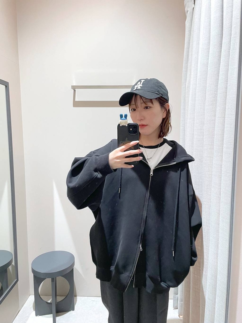 ブラック系のパーカー、ブラック系のキャップを着用したレディースの冬コーディネートの1枚目の写真