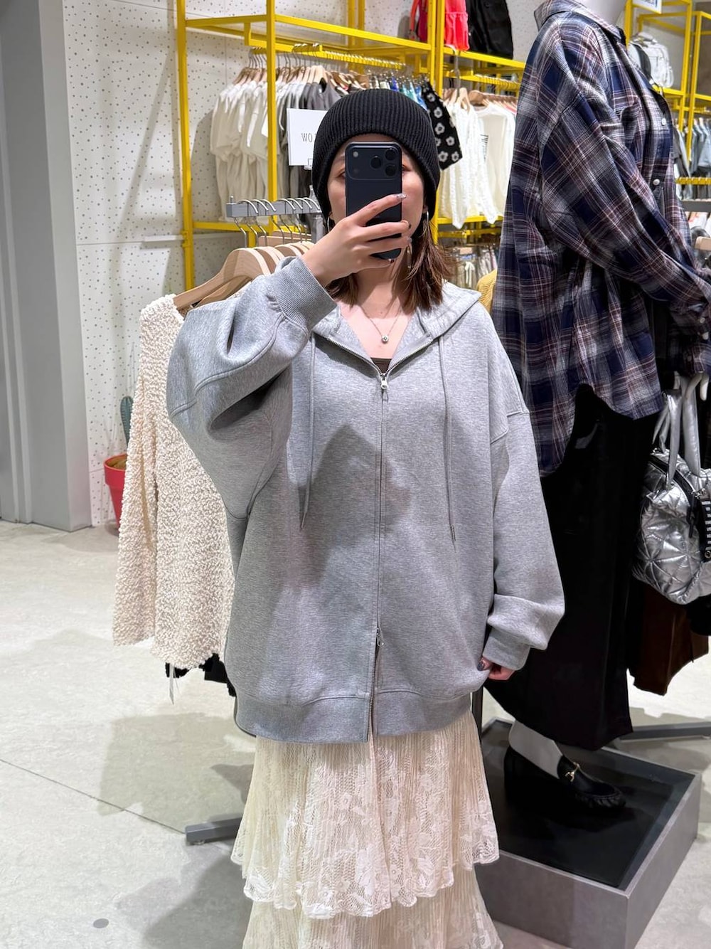 ホワイト系のスカート、グレー系のパーカーを着用したレディースの秋コーディネートの1枚目の写真