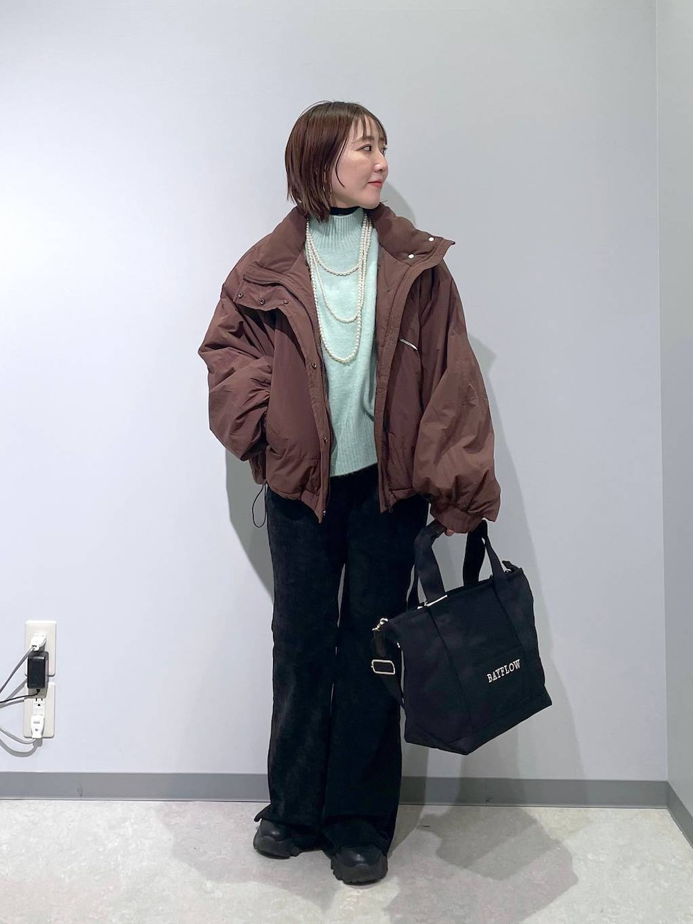 ブラウン系のその他アウター、グリーン系のニット/セーター、ブラック系のその他パンツを着用したレディースの冬コーディネートの1枚目の写真