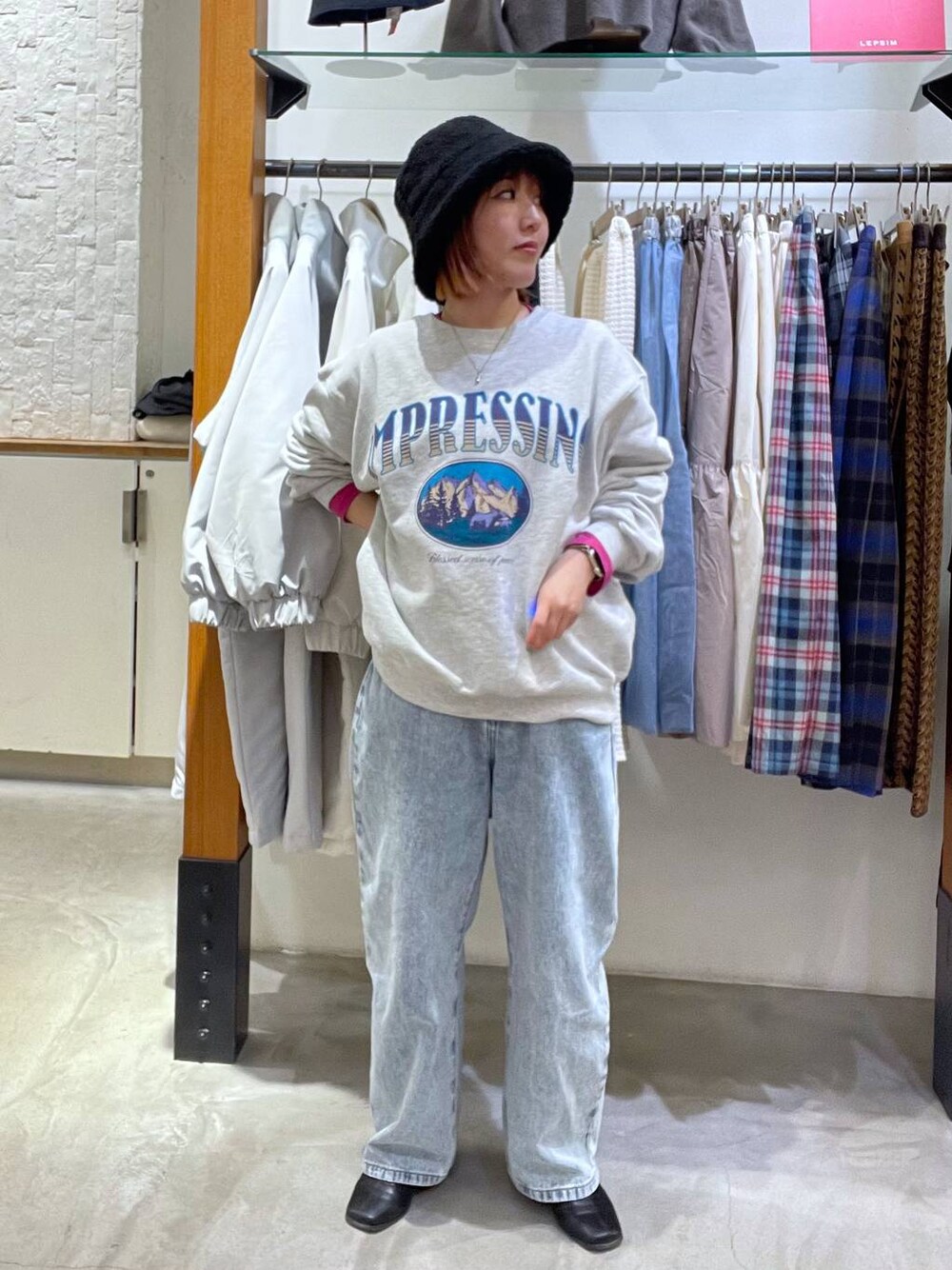 グレー系のスウェット、ブルー系のデニムパンツ、レッド系のTシャツ/カットソーを着用したレディースの冬コーディネートの1枚目の写真