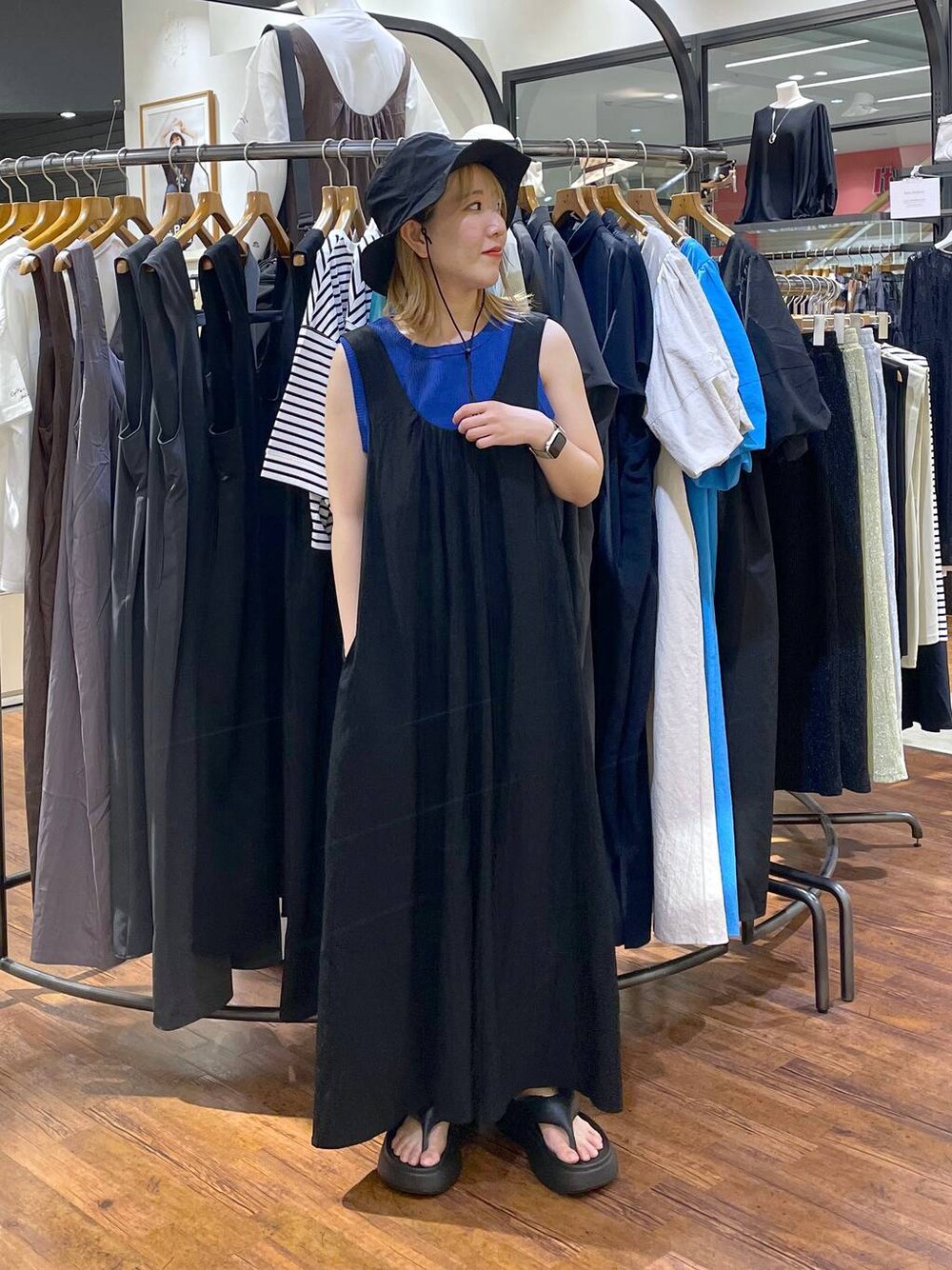 ブラック系のサンダル、ブルー系のタンクトップ、ブラック系のジャンパースカートを着用したレディースの夏コーディネートの1枚目の写真