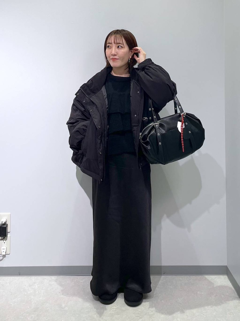 ブラック系のその他アウター、ブラック系のスカート、ブラック系のブーツを着用したレディースの冬コーディネートの1枚目の写真