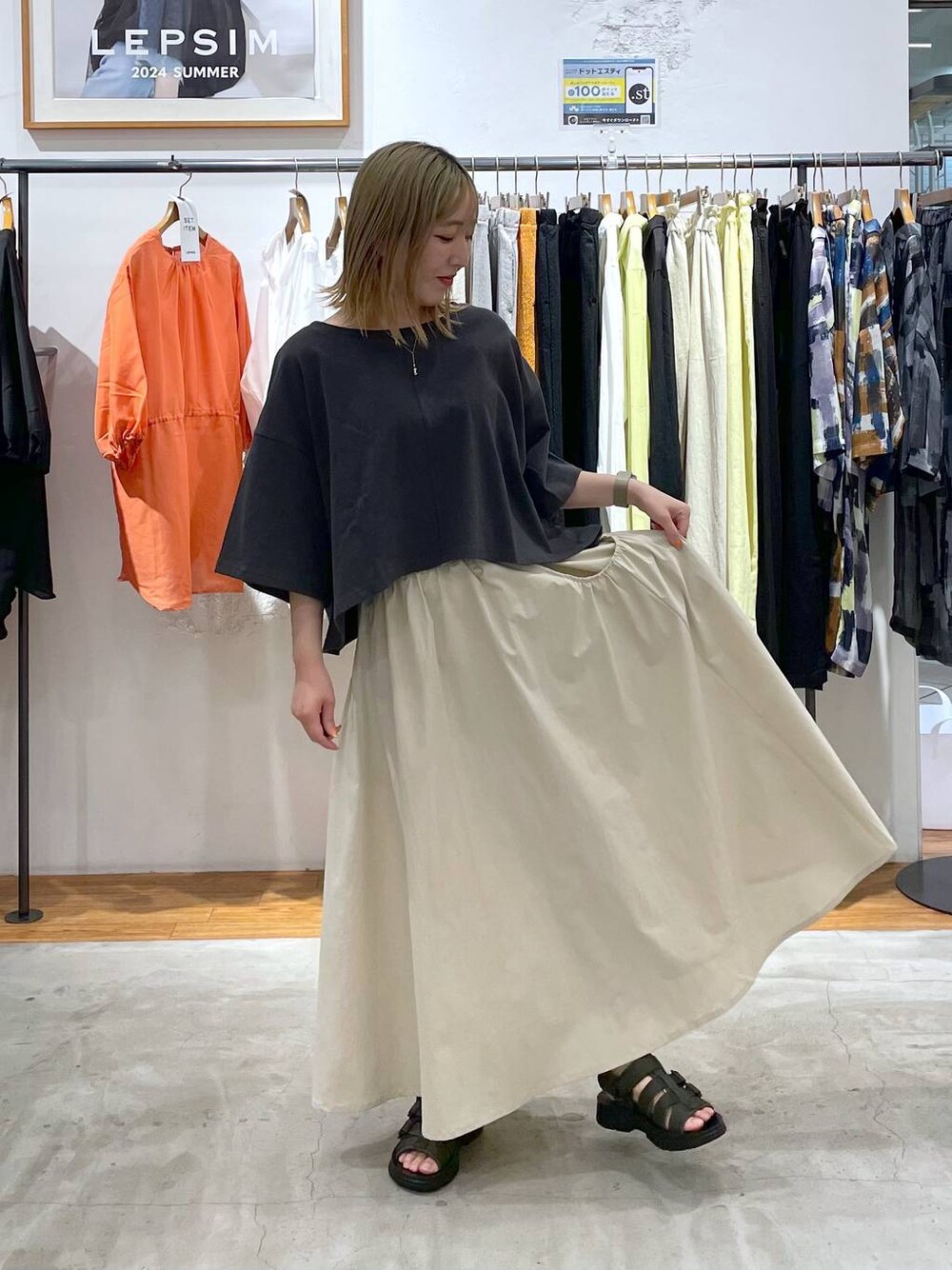 ホワイト系のスカート、グリーン系のサンダル、グレー系のTシャツ/カットソーを着用したレディースの夏コーディネートの1枚目の写真