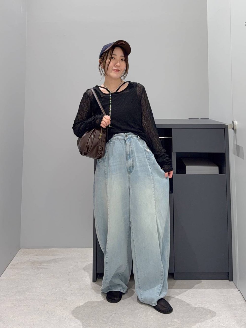ブラウン系のボストンバッグ、ブラック系のTシャツ/カットソー、ブルー系のデニムパンツを着用したレディースの夏コーディネートの1枚目の写真