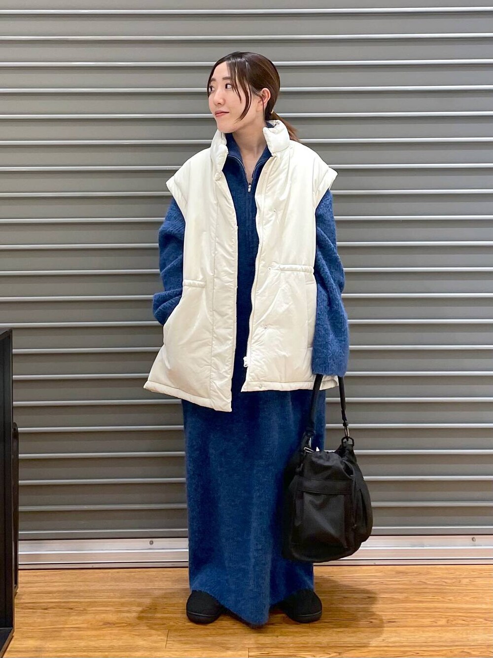 ホワイト系のその他アウター、ブラック系のその他シューズ、ブラック系のショルダーバッグを着用したレディースの冬コーディネートの1枚目の写真